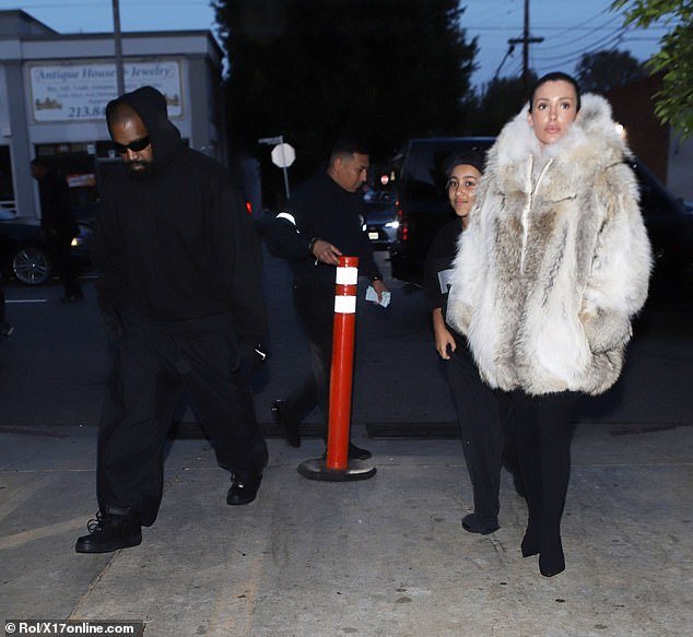 Bianca Censori, 29, abandonou sua aparência recente e atrevida e vestiu um casaco grosso enquanto saía para jantar com a enteada, North West, 10, e o marido Kanye West, 46, no sábado.