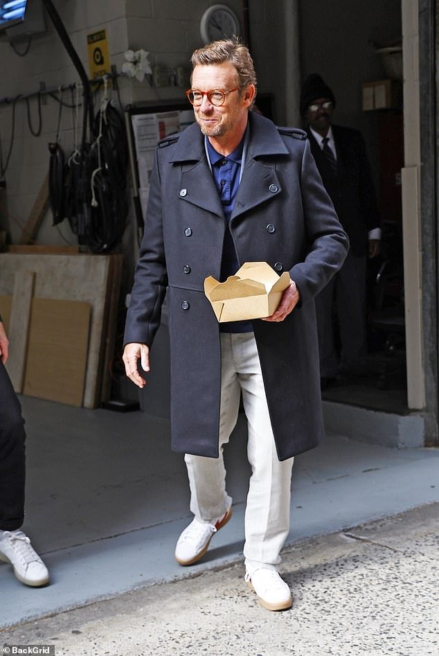 Simon Baker parecia elegante em um casaco de grife e calças brancas ao deixar o desfile de Kelly e Mark em Nova York na terça-feira